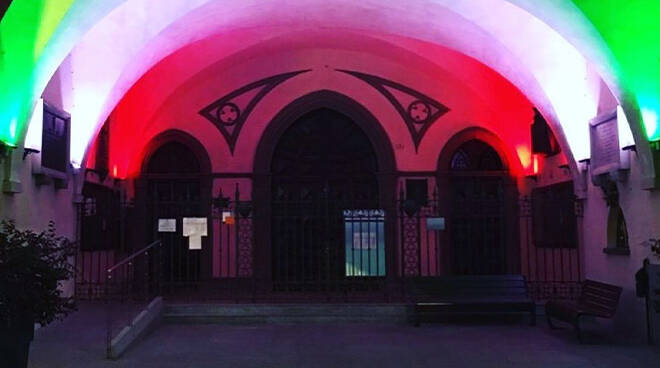 portici del Municipio e le torri di piazza Risorgimento illuminati con il tricolore